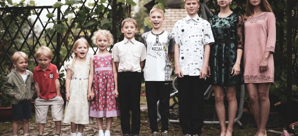 Happy group of children posing in garden setting, showing togetherness and joy.