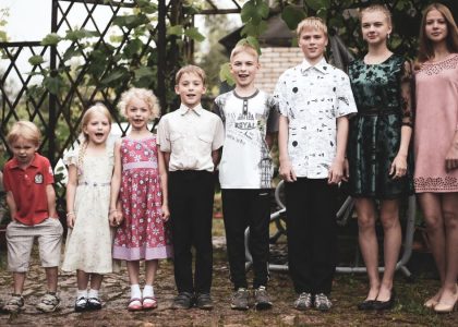 Happy group of children posing in garden setting, showing togetherness and joy.